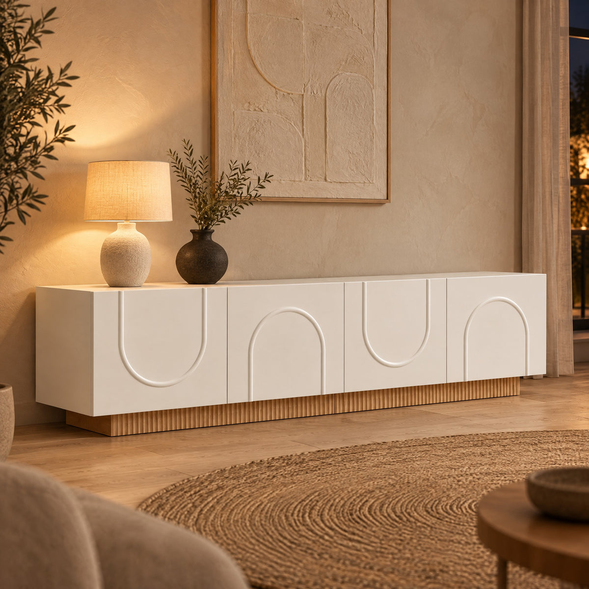 Meuble TV blanc portes en arche socle cannelé 170 cm, dans un salon le soir