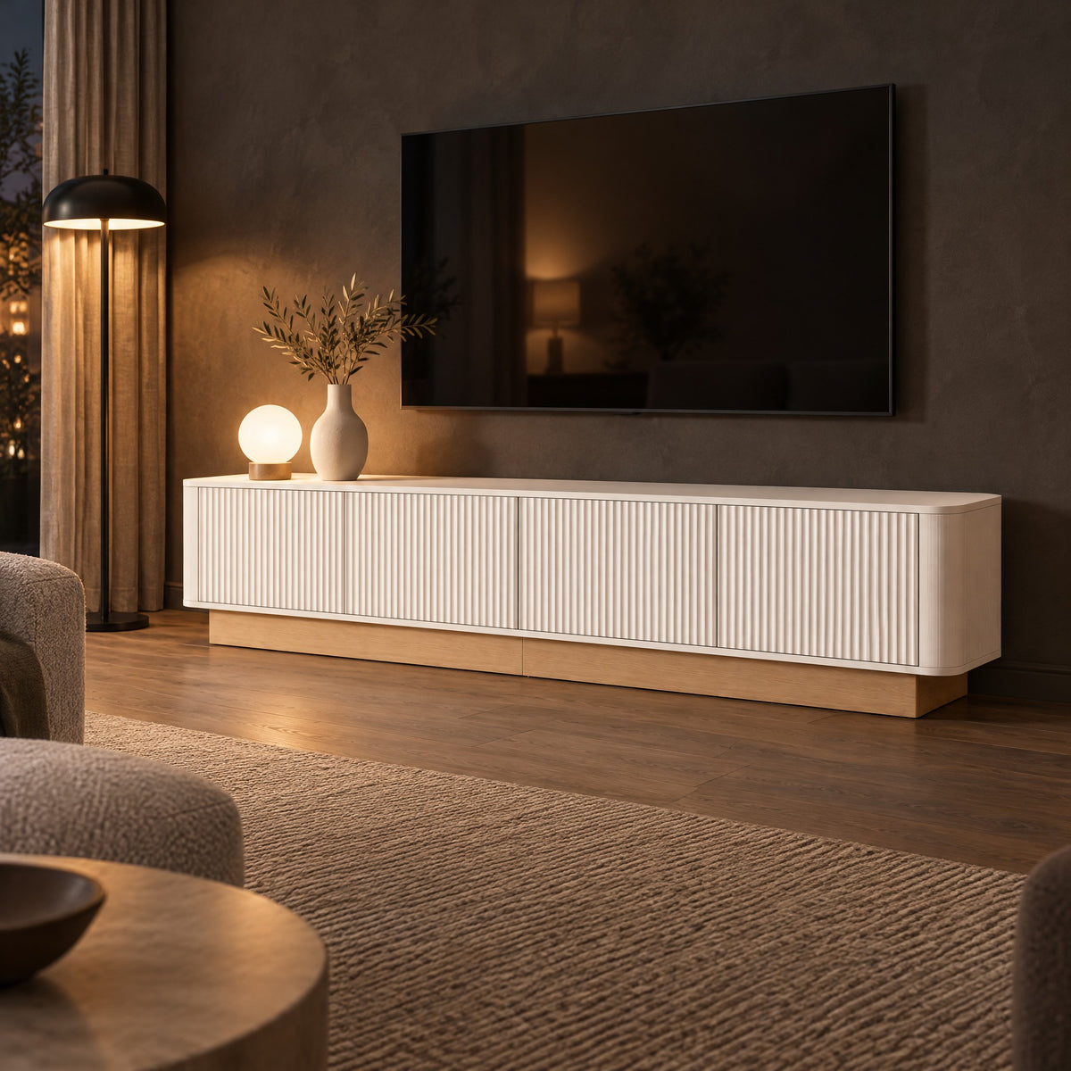 Meuble TV cannelé sur socle bois 200 cm, blanc, dans un salon le soir