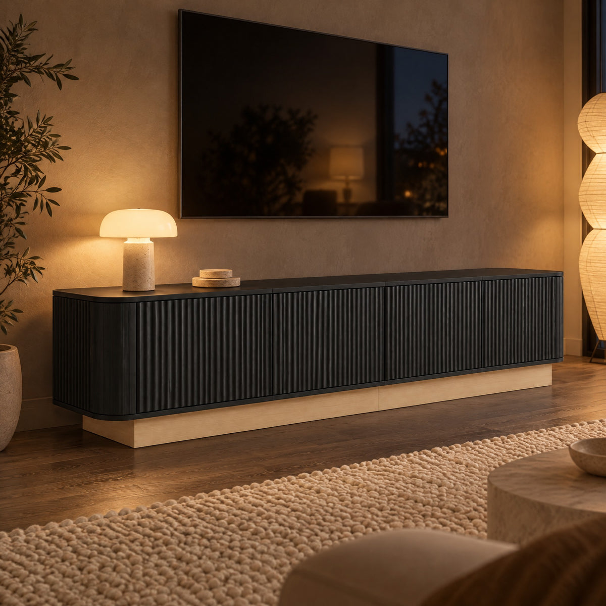 Meuble TV cannelé sur socle bois 200 cm, noir, dans un salon le soir