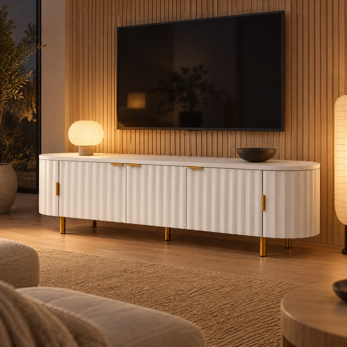 Meuble TV ovale blanc façade ondulée pieds dorés 170 cm, dans un salon le soir